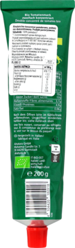 Tył zielonej tubki organicznego koncentratu pomidorowego 200g Alnatura z czerwonym korkiem, etykietą i kodem.