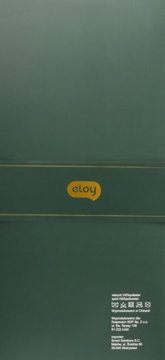 Ciemnozielone opakowanie Eloy z żółtym logo, widok z przodu, złote linie i symbole prania. Produkt tekstylny.