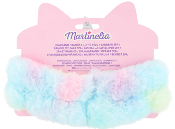 Puszysta opaska Martinelia w pastelowych kolorach tęczy, z małym pomponem, na różowym opakowaniu z uszami.