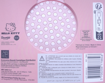 Widok z tyłu różowego produktu Hello Kitty z okrągłym panelem w białe kropki, ikonami baterii i ostrzeżeniami.