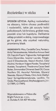 Tył rozświetlacza w sticku z polskimi instrukcjami, listą składników i danymi producenta na jasnoróżowym tle.