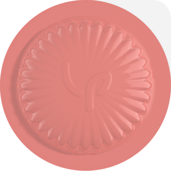 Pastelowy różowy, okrągły element dekoracyjny z wytłoczonym logo i żłobionym brzegiem, matowe wykończenie, widok z góry.