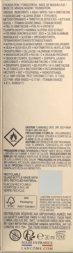 Złoty tył opakowania podkładu Lancôme Teint Idole Ultra Wear ze składnikami, ostrzeżeniami i recyklingiem.