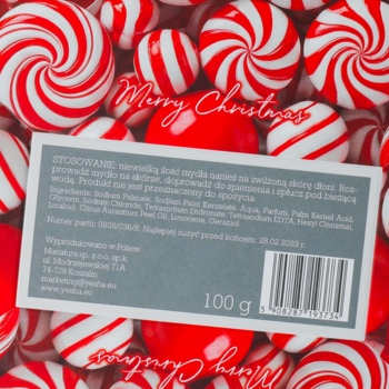 Etykieta naturalnego mydła na tle czerwono-białych cukierków miętowych, z napisem „Merry Christmas”.