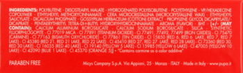 Tył opakowania pomadki, czerwone tło z białym napisem "INGREDIENTS" i pełną listą składników produktu.