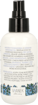 Tył butelki toniku-mgiełki Vianek w białej butelce z czarnym atomizerem, z etykietą z niebieskimi kwiatami i tekstem.