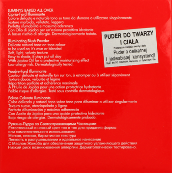 Tył czerwonego opakowania pudru rozświetlającego do twarzy i ciała. Biała etykieta z tekstem o delikatnej konsystencji.