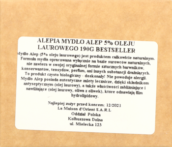 Biała etykieta mydła Aleppo 5% oleju laurowego 190g na jasnobrązowym papierowym opakowaniu, widok z przodu.