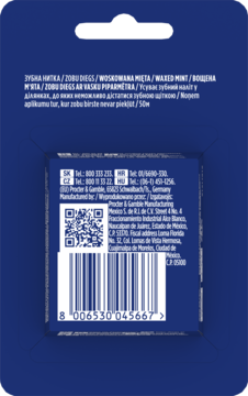 Tył niebieskiego opakowania nici dentystycznej Oral-B Essential Waxed Mint z widocznym kodem kreskowym i etykietą.