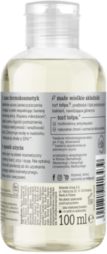 Tył przezroczystej butelki torf tołpa 100ml dermokosmetyku z białym korkiem, widoczne etykiety i składniki.