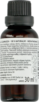 Zbliżenie na tył brązowej butelki Arganove 100% naturalnego oleju z czarnuszki, 30 ml, z etykietą i opisem.