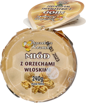 Miód Pszczelarz Kozacki z orzechami włoskimi, 240g, okrągły słoik z etykietą o wzorze plastra miodu, widok z góry.