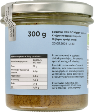 Tył szklanego słoika z ekologiczną pastą migdałową 300g, widoczna etykieta ze składem i datą ważności.
