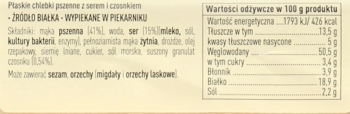 Zbliżenie na beżową etykietę chlebków pszennych z serem i czosnkiem, pokazującą tabelę wartości odżywczych.