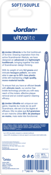 Tył opakowania szczoteczki Jordan Ultralite Soft. Opisuje, że waży 9.2g, 50% mniej plastiku, z białym tłem i niebieskimi napisami.