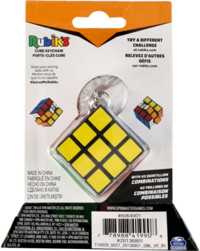 Rubik's Cube brelok z żółtymi polami, w przezroczystym blistrze, na pomarańczowo-białym kartoniku, widok z przodu.