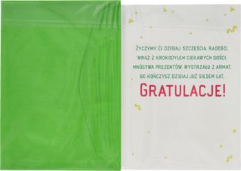 Biały karnet urodzinowy dla 7-latka z czerwonym napisem "GRATULACJE!" i żółtym konfetti, częściowo w zielonej folii.