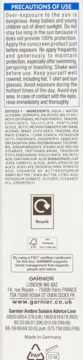 Tył opakowania Garnier Ambre Solaire Sensitive Advanced SPF 50+ serum, biała kartka z instrukcjami i logo.
