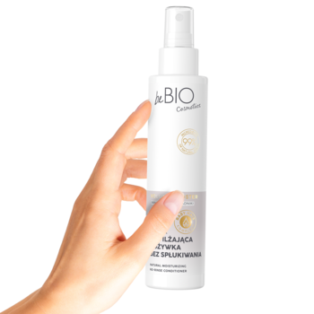 Biała butelka sprayu beBIO Cosmetics, odżywka do włosów bez spłukiwania, trzymana w dłoni.