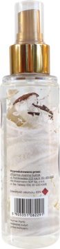 Tył przezroczystej mgiełki Scent of Beauty Coconut Vanilla. Widoczne białe płatki kokosa i etykieta produktu.