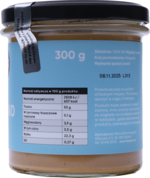 Tył szklanego słoika 300g z BIO pastą migdałową Ekogram. Niebieska etykieta z tabelą wartości odżywczych.