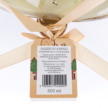 Zbliżenie na etykietę Yesha olejek do kąpieli pomarańcza z cynamonem 500 ml, z motywem choinek i kokardą.