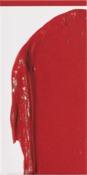 Zbliżenie na intensywny, czerwony róż do policzków o kremowej, gęstej konsystencji i błyszczącym wykończeniu.