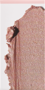 Rozświetlacz: kremowy, różowo-złoty swatch o perłowym połysku, ukazujący teksturę i efekt glass skin.