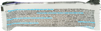 Crumpled white label of a protein bar (26% protein), blurry Polish text with blue highlights, for pre/post-workout.