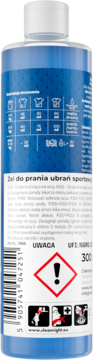 Tył butelki niebieskiego żelu do prania ubrań sportowych z białym korkiem, widoczne instrukcje i etykiety ostrzegawcze.
