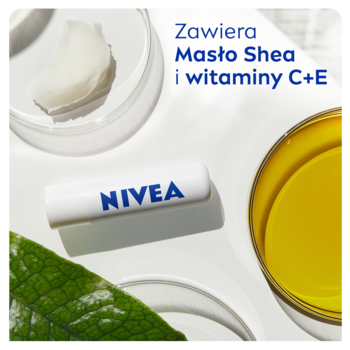 NIVEA Med Repair pomadka w białym opakowaniu na laboratoryjnym tle, obok masło shea i żółty olej z góry.
