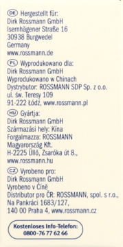 Biała etykieta Rossmann, zawiera dane producenta, dystrybutorów i numer telefonu w wielu językach, pełny widok.