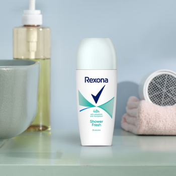 Damski antyperspirant Rexona Shower Fresh 48h w białej kulce z niebieskimi detalami, na łazienkowej półce.