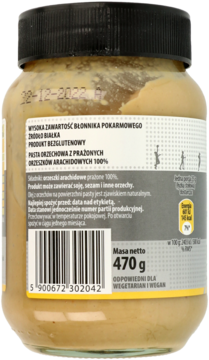 Tył słoika 100% masła orzechowego bez glutenu, bogatego w błonnik. Widoczna etykieta z datą 22-12-2022.