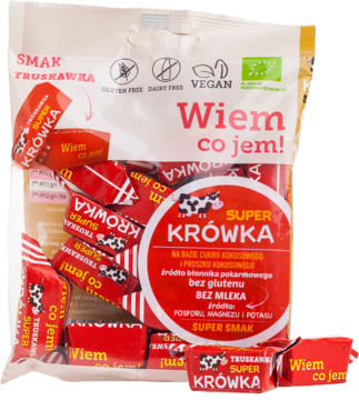 Opakowanie wegańskich, bezmlecznych krówek truskawkowych Super Krówka z czerwonymi cukierkami na zewnątrz.