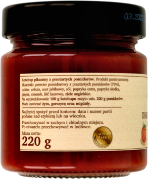 Tył szklanego słoika pikantnego ketchupu z przetartych pomidorów, z etykietą i masą 220g. Data na wieczku.