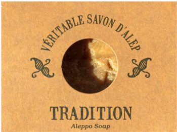 Mydło d'Alep Tradition 190g w jasnobrązowym kartoniku, z okrągłym wycięciem na beżowe mydło.