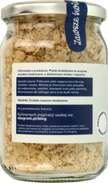 Tył szklanego słoika z płatkami drożdżowymi. Widoczna etykieta z polskim opisem produktu i niebieską zawieszką.