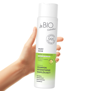Biała butelka beBIO Super Hydration intensywnie nawilżającego szamponu z zieloną etykietą, trzymana w dłoni.