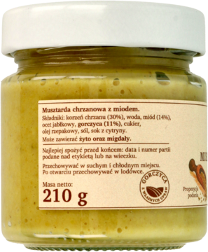 Tył szklanego słoika z żółtą musztardą chrzanową z miodem. Widoczna etykieta z polskim opisem i wagą 210g.