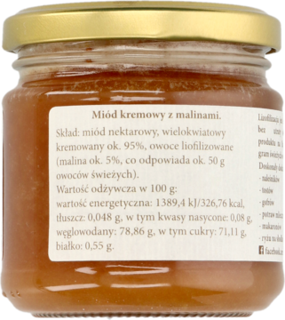 Szklany słoik kremowego miodu z malinami, brązowo-pomarańczowy, widoczna tylna etykieta ze składem produktu.