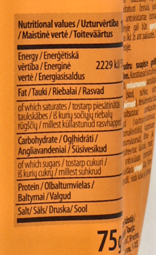 Częściowy widok pomarańczowego opakowania chipsów ziemniaczanych. Zbliżenie na tabelę wartości odżywczych, w tym Energy 2229 kJ.