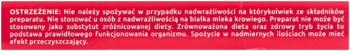 Czerwona etykieta Fiorda Junior z rozmytym, białym tekstem ostrzeżenia, widok z bliska.