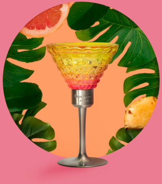 Pepe Jeans Cocktail Edition, woda toaletowa, flakon-kieliszek w gradientach różu i żółci, na tle tropikalnych liści i owoców.