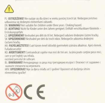Zbliżenie na etykietę ostrzegawczą zabawki, symbol 0-3 i CE, ostrzeżenia o ryzyku zadławienia dla dzieci poniżej 3 lat.
