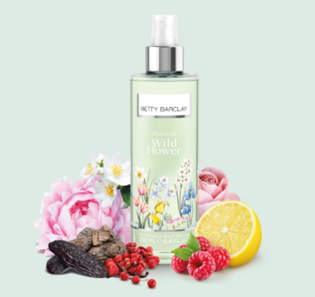 Betty Barclay Wild Flower mgiełka w przezroczystej butelce. Obok: cytryna, maliny, piwonia, jaśmin. Zielone tło.