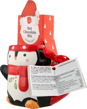 Biały ceramiczny kubek-pingwin z czerwonym szalikiem i czapką, w nim Hot Chocolate Mix, świąteczny zestaw.