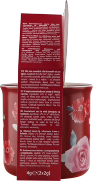 Bok czerwonego opakowania herbaty czarnej aromatyzowanej cytryną, z detalami składu, obok dwa czerwone kubki w kwiaty.