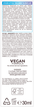 Tył serum Garnier Ambre Solaire Invisible SPF 50+, biała etykieta z instrukcjami, składem i oznaczeniami wegańskimi.