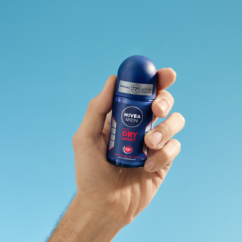 Niebieski NIVEA MEN Dry Impact 72h antyperspirant w kulce, trzymany w męskiej dłoni na tle błękitnego nieba.